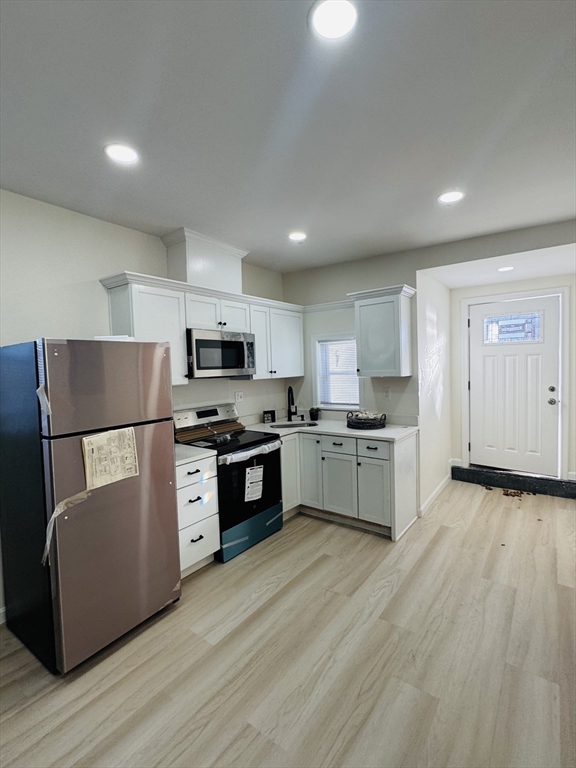 73 Victoria Street Revere, MA 02151 - Photo 9 of 24 a kitchen with white cabinets and stainless steel appliances