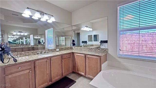 a bathroom with a granite countertop sink and a large mirror