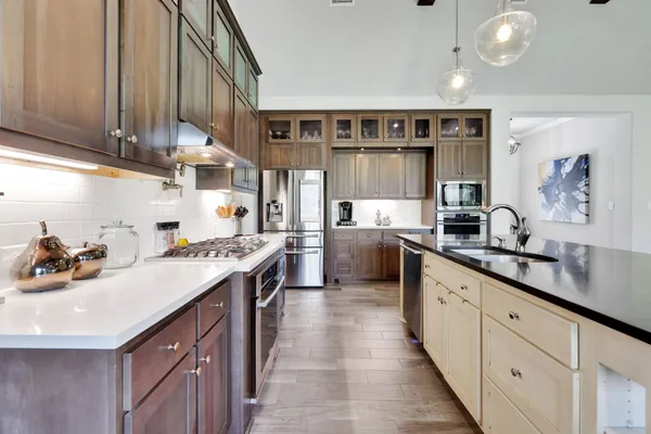 a kitchen with stainless steel appliances granite countertop a stove and a view of living room