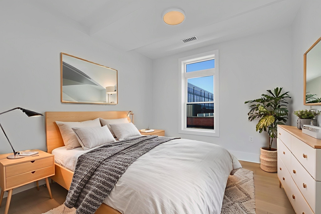 62 Foundry Street, Unit 414 Wakefield, MA 01880 - Photo 3 of 24 a bedroom with a bed and a potted plant