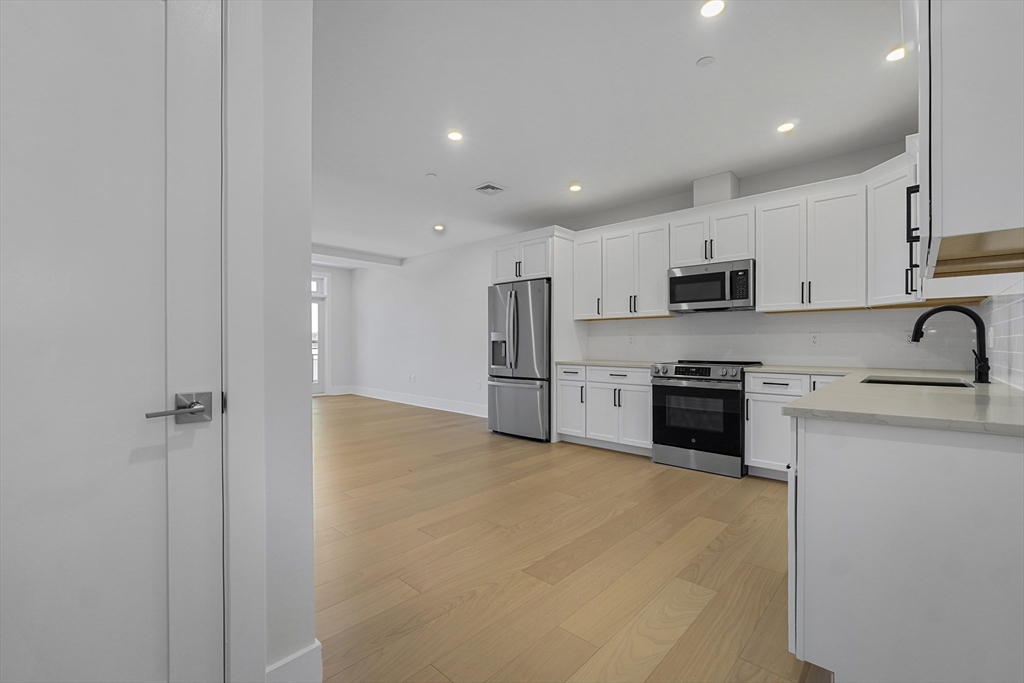 62 Foundry Street, Unit 414 Wakefield, MA 01880 - Photo 9 of 24 a kitchen with stainless steel appliances a refrigerator a stove top oven a sink and cabinets