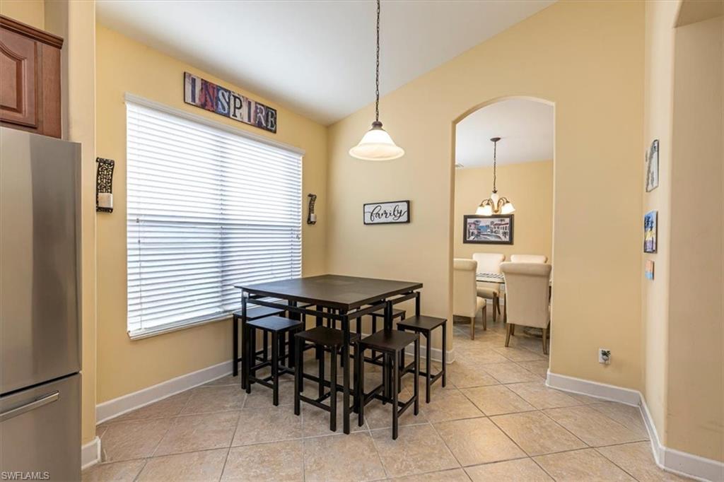 1674 Serrano Circle Naples, FL 34105 - Photo 14 of 21 Dining space featuring arched walkways, light tile patterned floors, and lofted ceiling