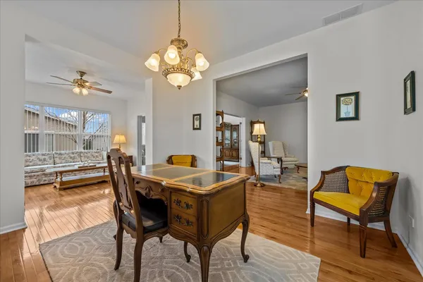 a dining room with wooden floor and chandelier