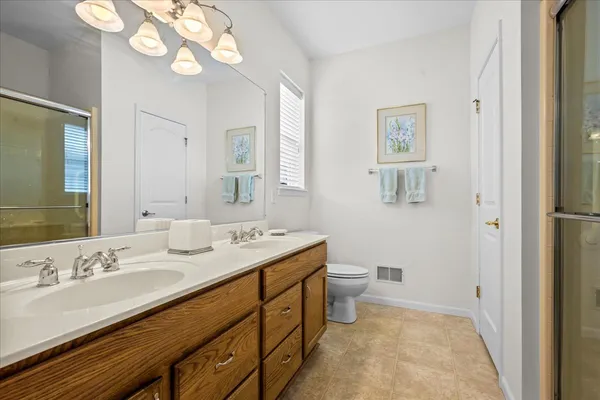 a spacious bathroom with a granite countertop sink a toilet and a mirror
