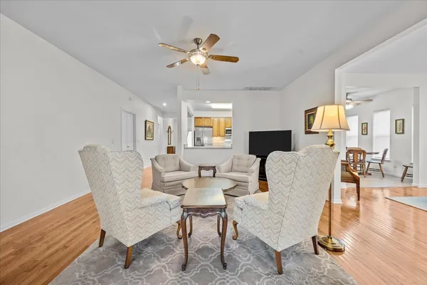 a living room with furniture or chandelier and a wooden floor