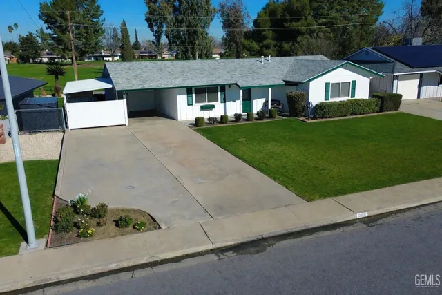 a front view of a house with a garden and trees