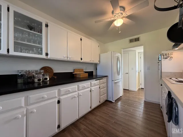 a kitchen with stainless steel appliances granite countertop a sink a stove and a refrigerator