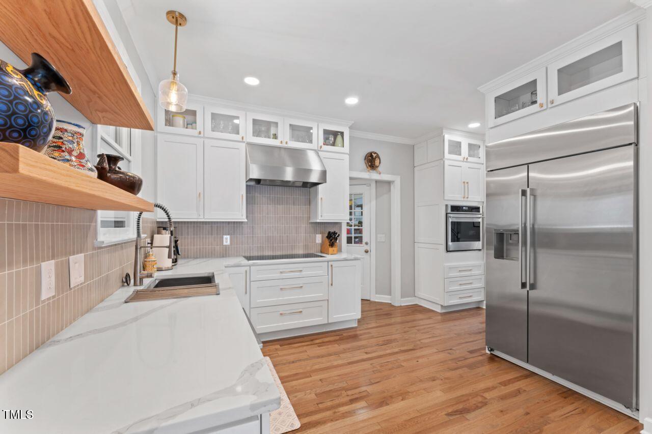 4408 Queenstown Court Raleigh, NC 27612 - Photo 15 of 49 a kitchen with stainless steel appliances kitchen island granite countertop a refrigerator and a sink