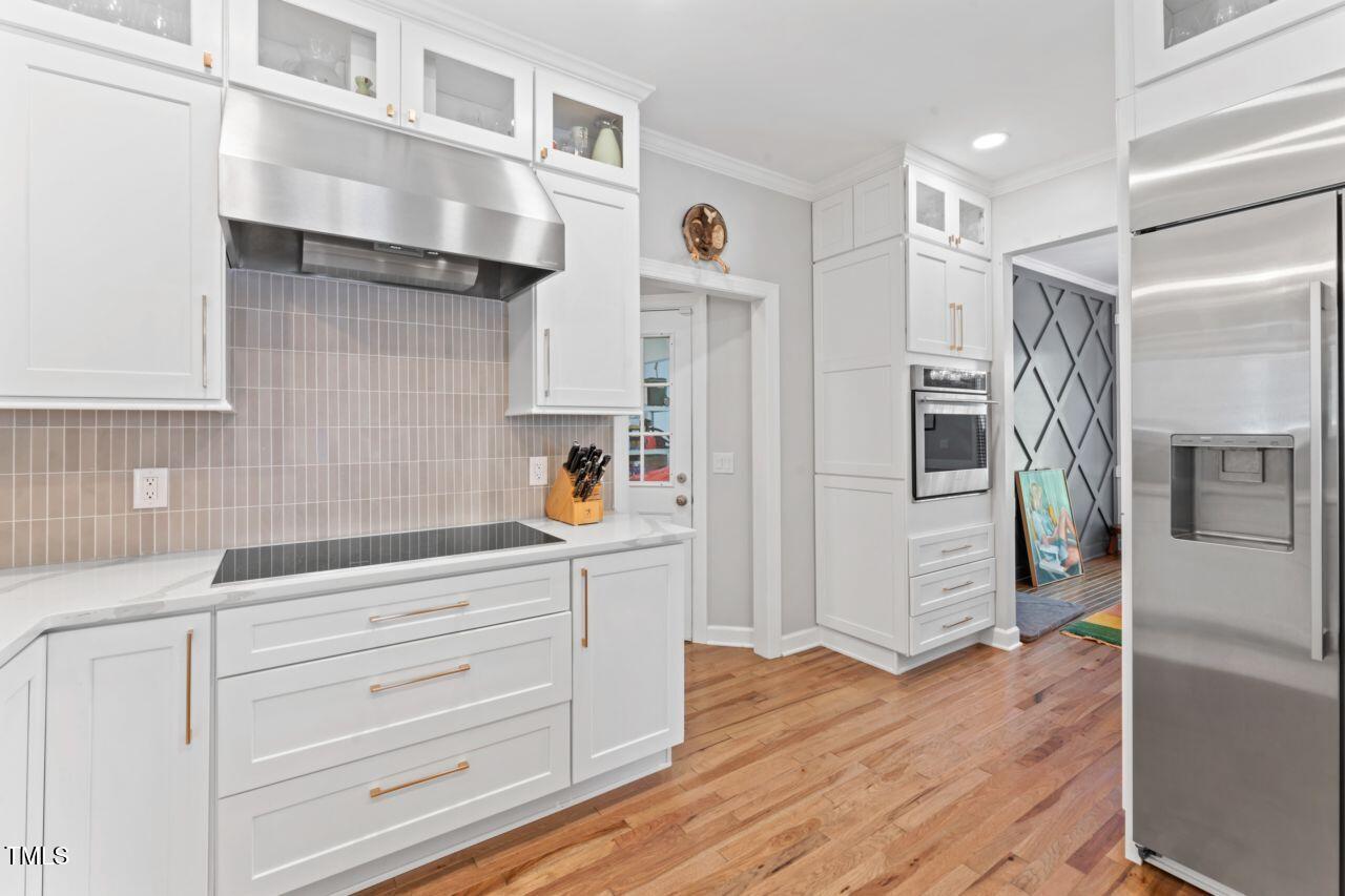 4408 Queenstown Court Raleigh, NC 27612 - Photo 17 of 49 a kitchen with stainless steel appliances cabinets and a wooden floor