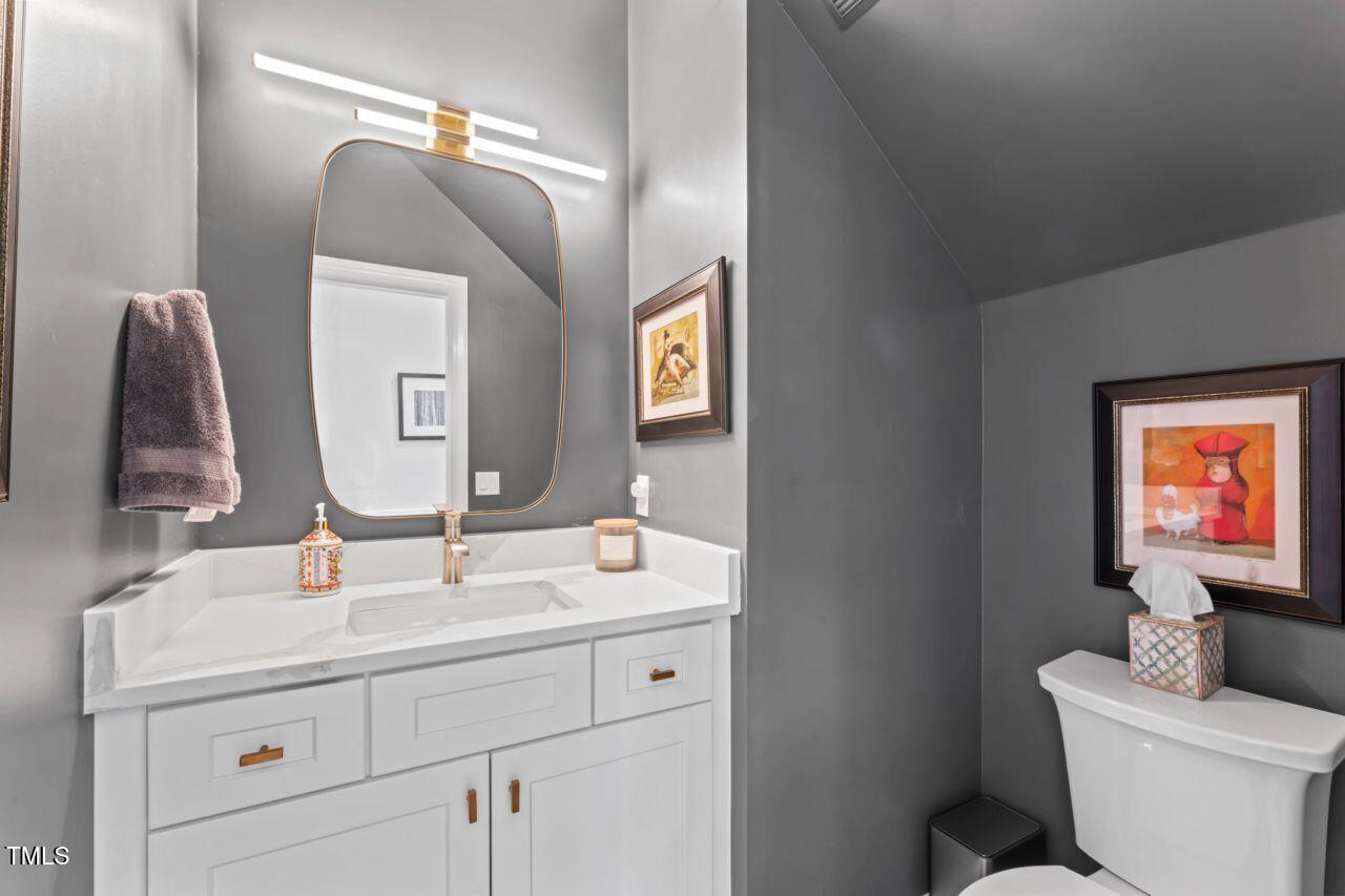 4408 Queenstown Court Raleigh, NC 27612 - Photo 22 of 49 a bathroom with a toilet sink and mirror
