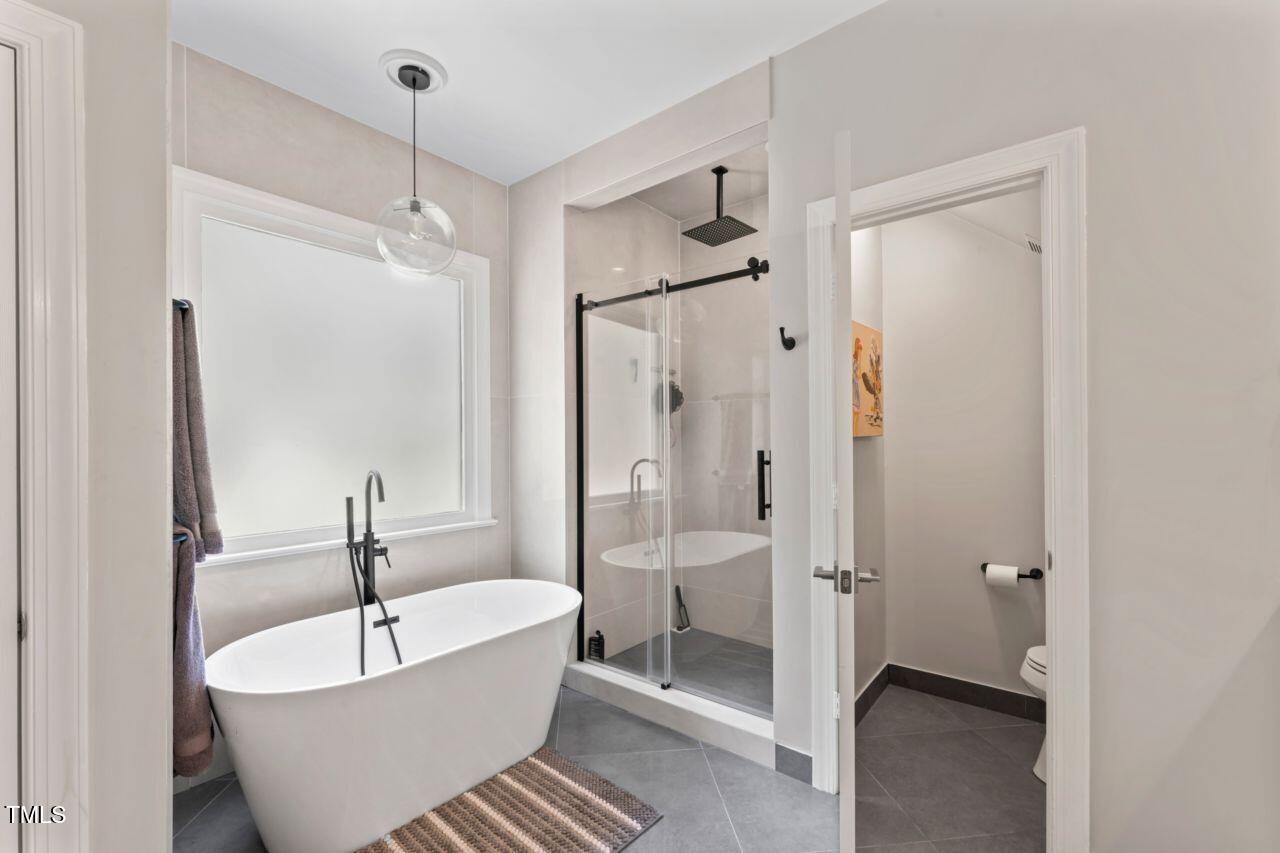 4408 Queenstown Court Raleigh, NC 27612 - Photo 26 of 49 a bathroom with a white tub shower and closet