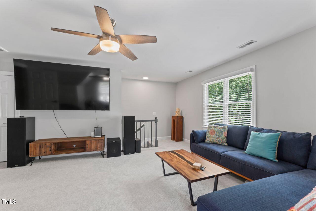 4408 Queenstown Court Raleigh, NC 27612 - Photo 29 of 49 a living room with furniture and a flat screen tv