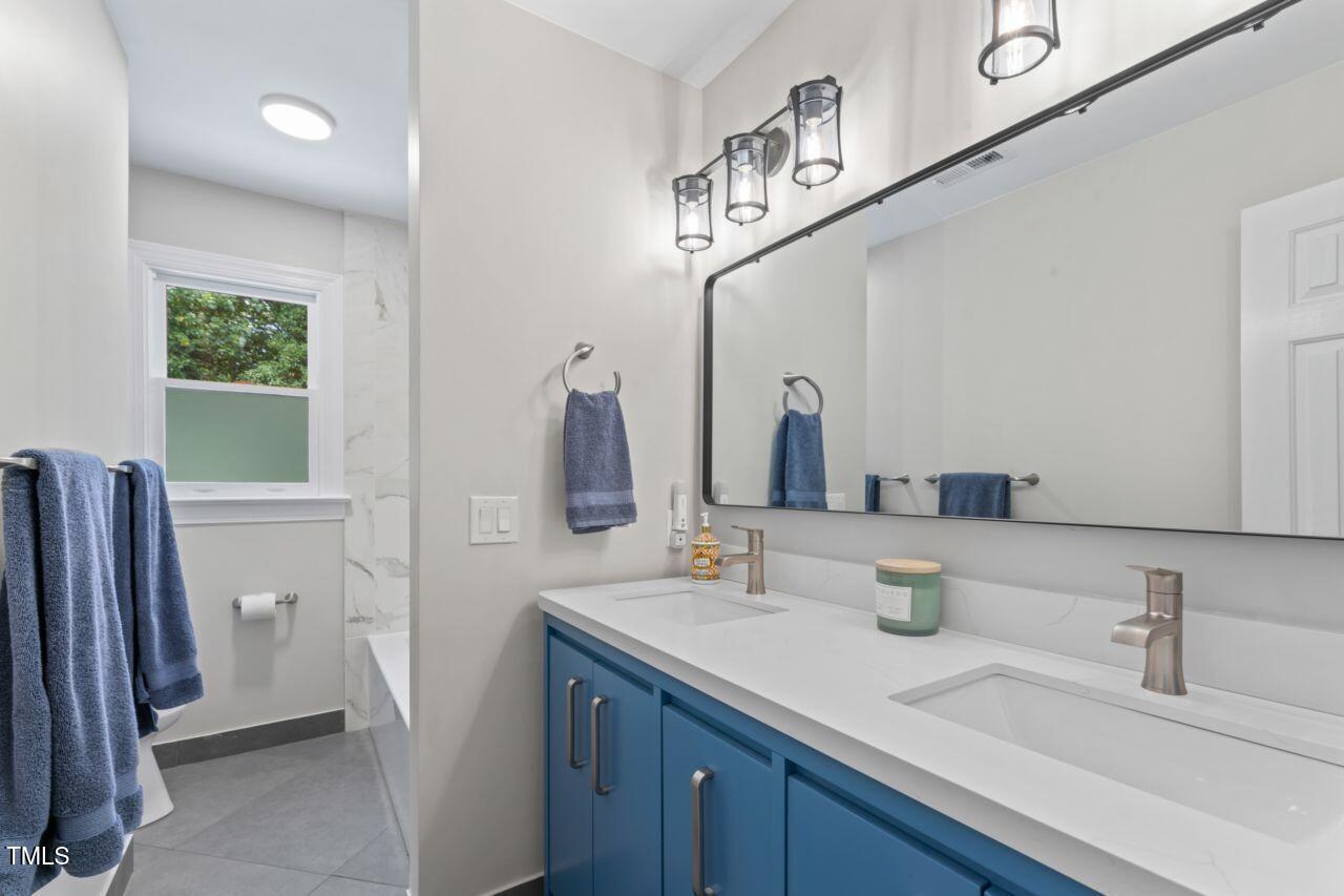 4408 Queenstown Court Raleigh, NC 27612 - Photo 40 of 49 a bathroom with a sink and a mirror