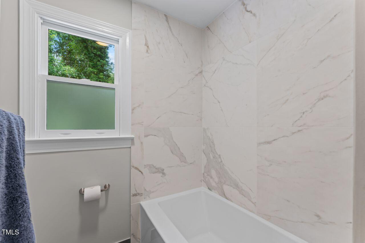 4408 Queenstown Court Raleigh, NC 27612 - Photo 41 of 49 a bathroom with a tub and window