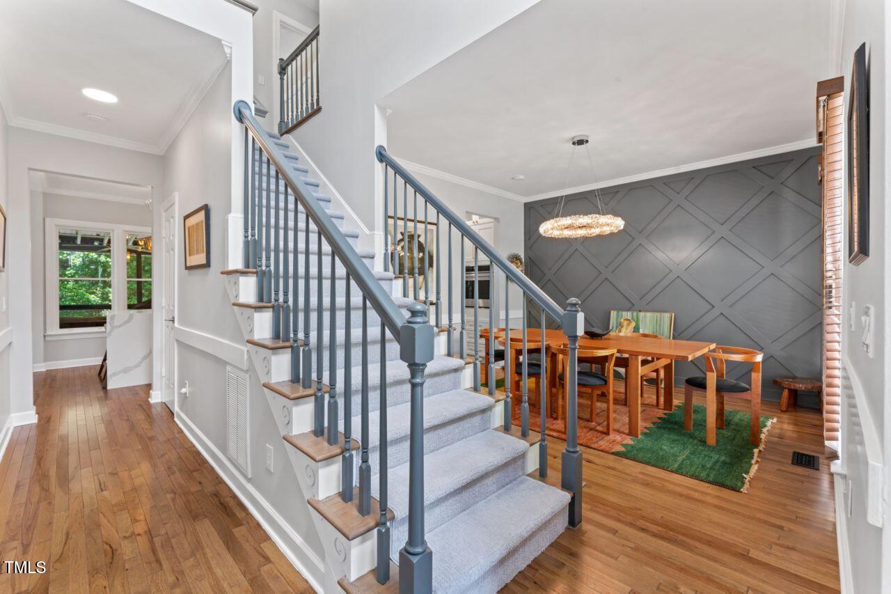 4408 Queenstown Court Raleigh, NC 27612 - Photo 6 of 49 a view of staircase with lots of frames on wall and wooden floor