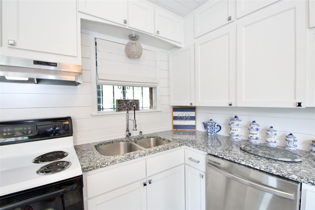 1307 North 65th Street Waco, TX 76710 - Photo 14 of 35 a kitchen with granite countertop a sink a stove and cabinets