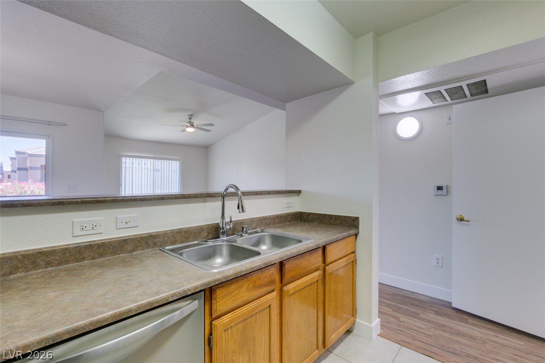 6650 West Warm Springs Road, Unit 2118 Las Vegas, NV 89118 - Photo 3 of 41 A well-lit kitchen with natural wood cabinetry and a double basin stainless steel sink.