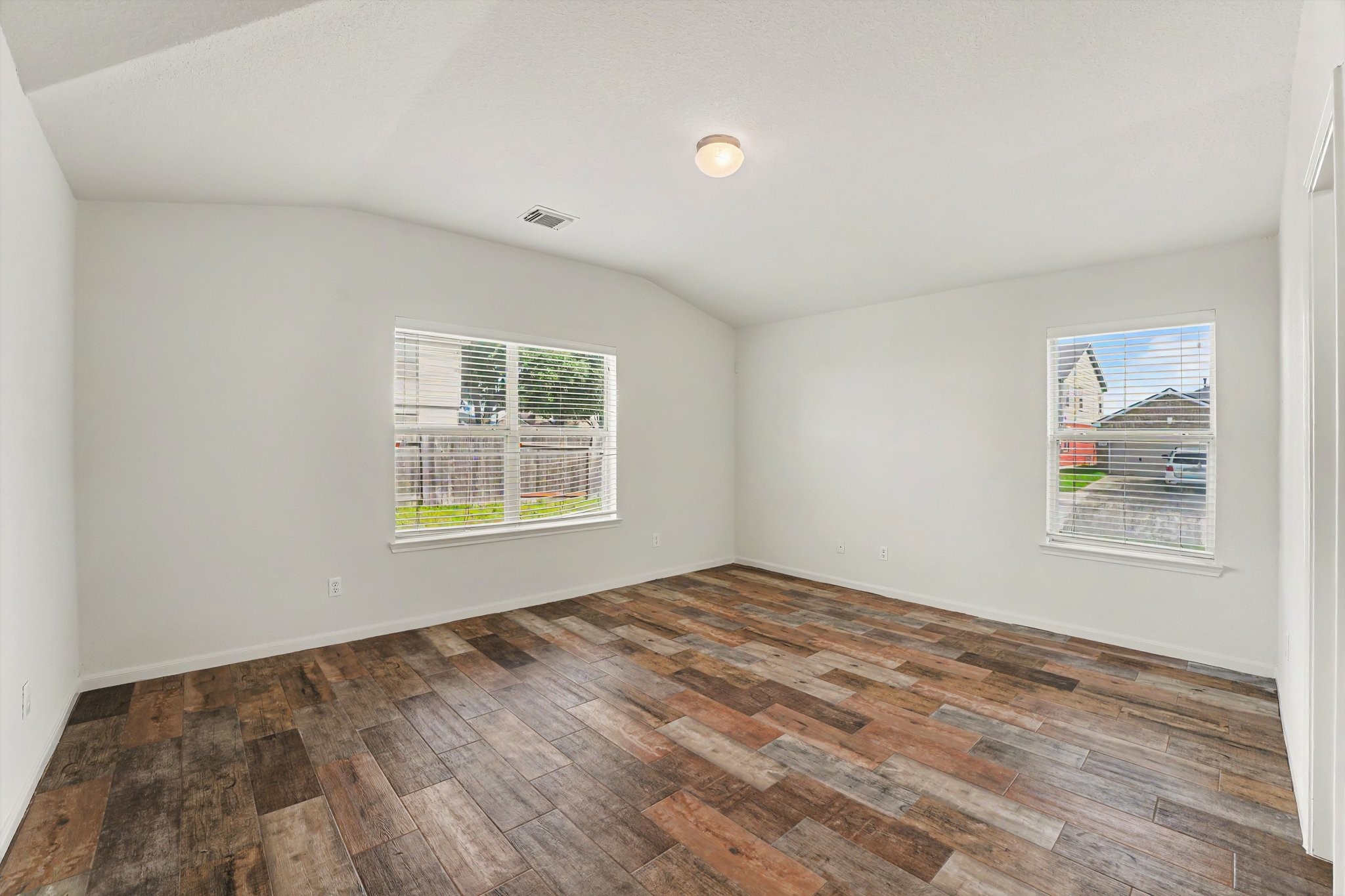 21427 Blooming Rock Lane Spring, TX 77379 - Photo 17 of 32 Bright and spacious room with high ceilings and large windows. Features elegant wood-look flooring and neutral walls, providing a versatile space ready for personalization.