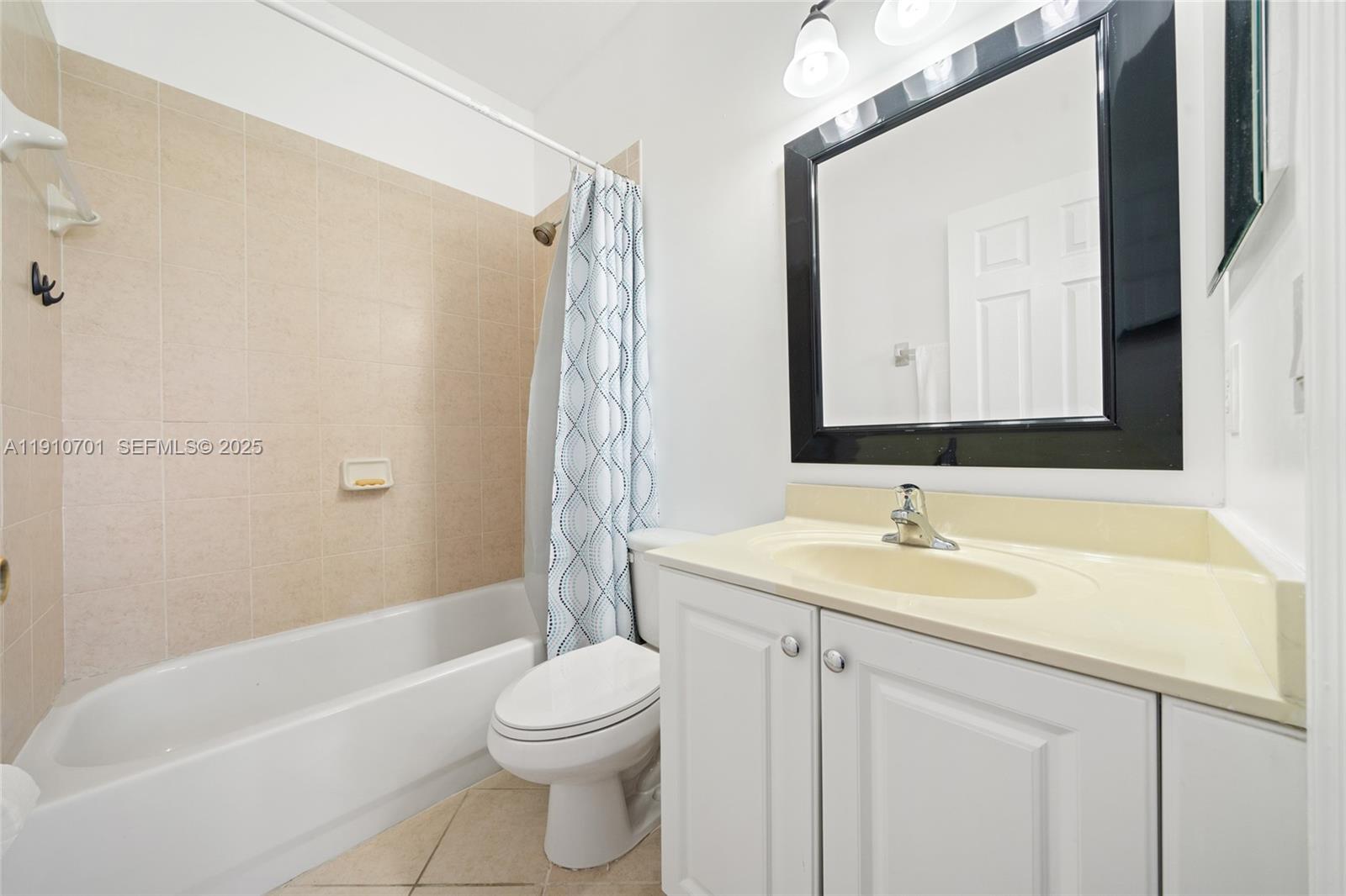 23713 Southwest 115th Avenue Homestead, FL 33032 - Photo 16 of 26 a bathroom with a sink a toilet and a mirror