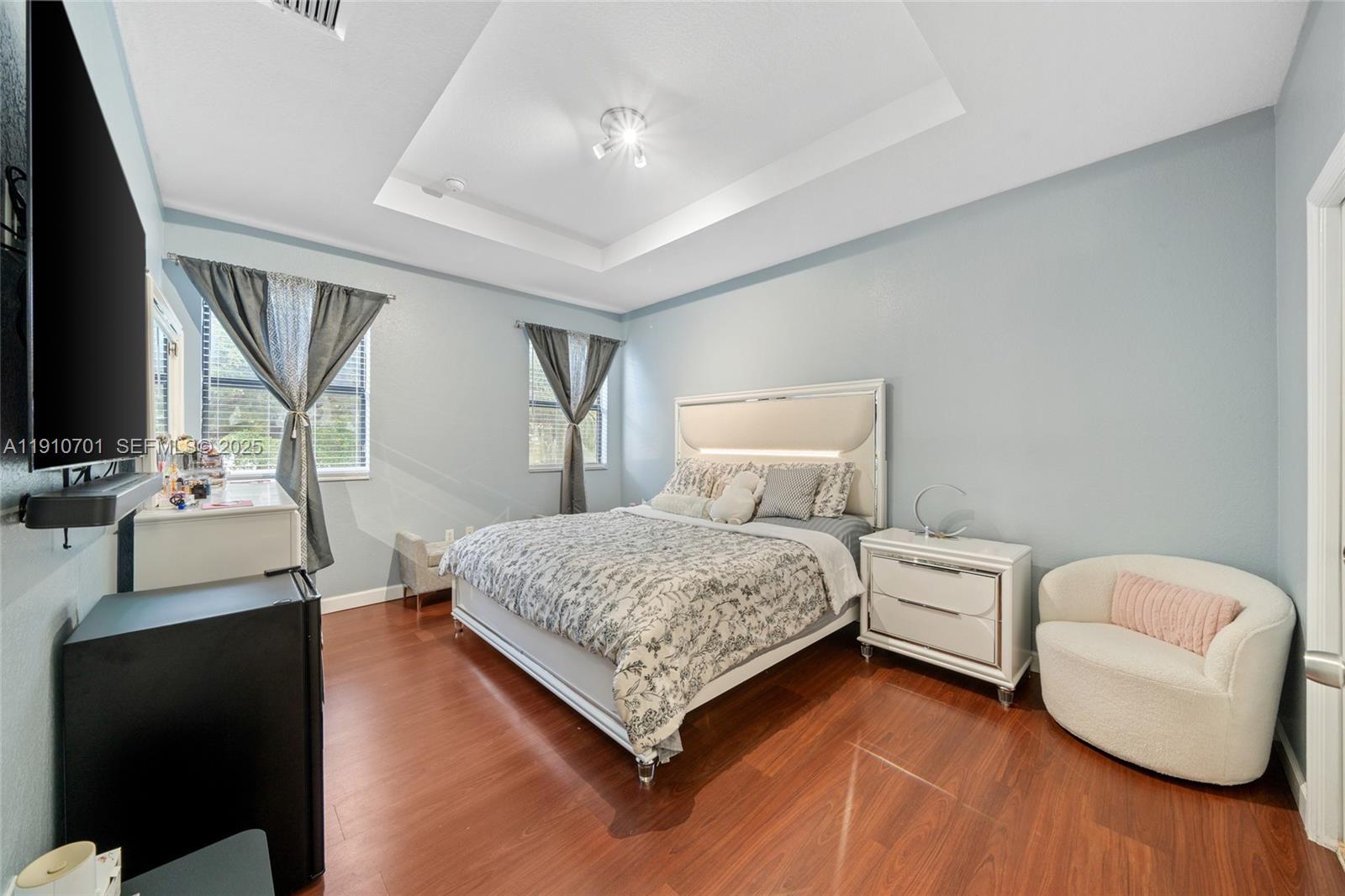 23713 Southwest 115th Avenue Homestead, FL 33032 - Photo 19 of 26 a bedroom with a bed couch and a flat screen tv