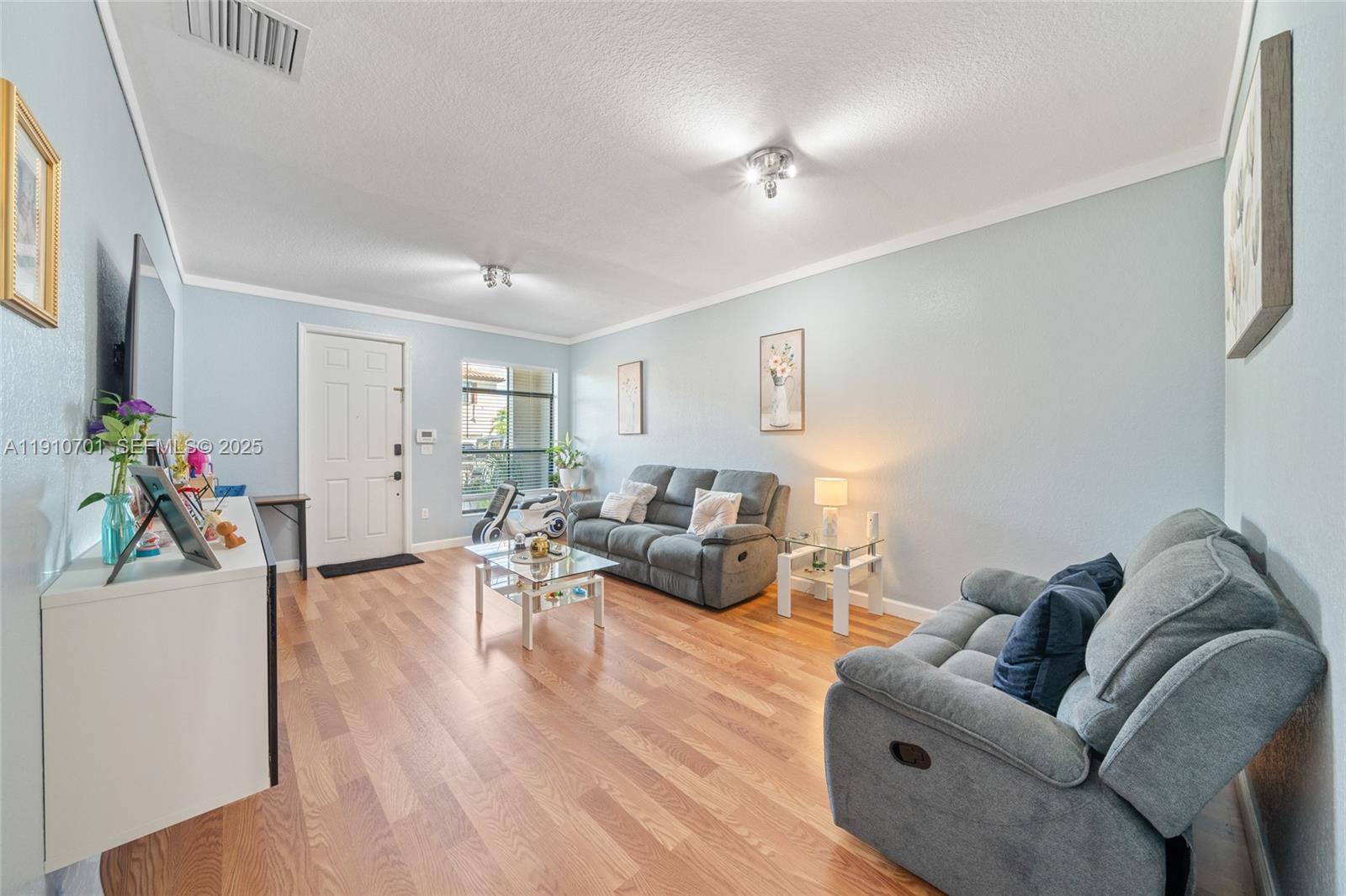 23713 Southwest 115th Avenue Homestead, FL 33032 - Photo 2 of 26 a living room with furniture and wooden floor
