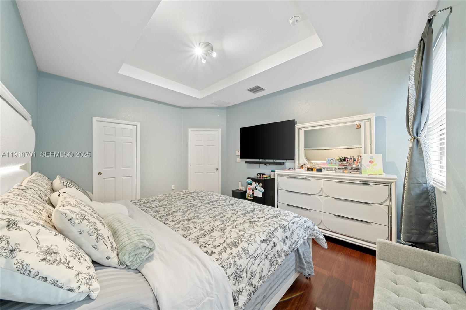 23713 Southwest 115th Avenue Homestead, FL 33032 - Photo 8 of 26 a bedroom with a bed and a flat screen tv