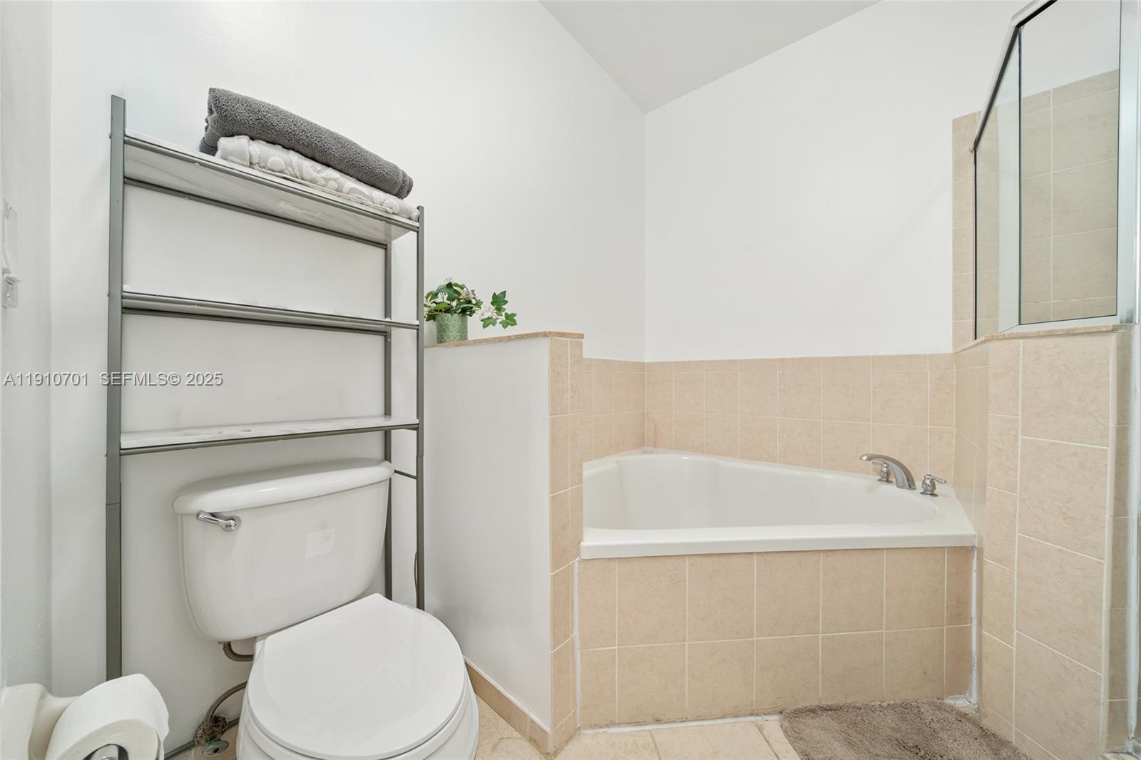 23713 Southwest 115th Avenue Homestead, FL 33032 - Photo 10 of 26 a white toilet sitting next to a bathroom sink and tub