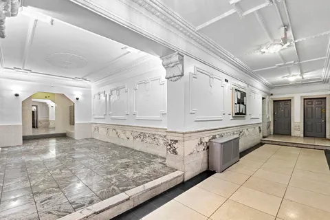 a large white kitchen with granite countertop a sink and white cabinets