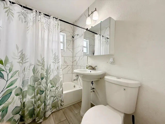 a bathroom with a sink toilet and shower