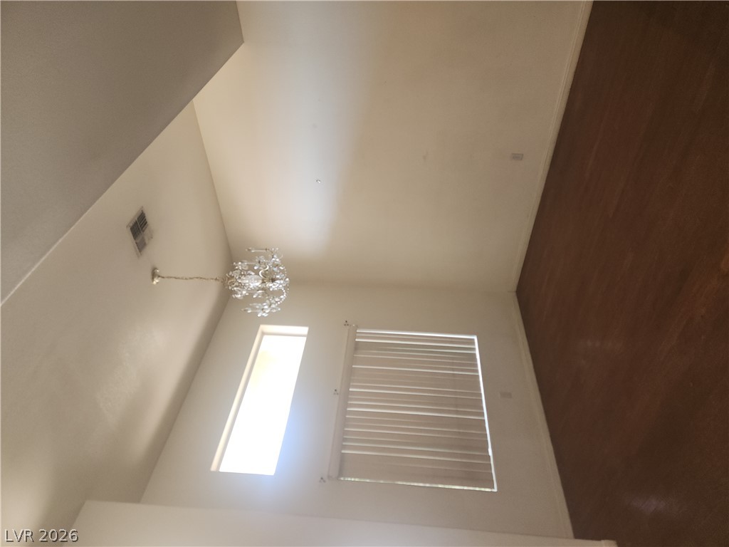 564 Ridgeway Road Henderson, NV 89015 - Photo 4 of 22 Natural light illuminates rich hardwood flooring beneath a captivating chandelier in this inviting living space.