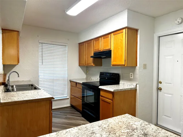 a kitchen with a sink appliances cabinets and a window