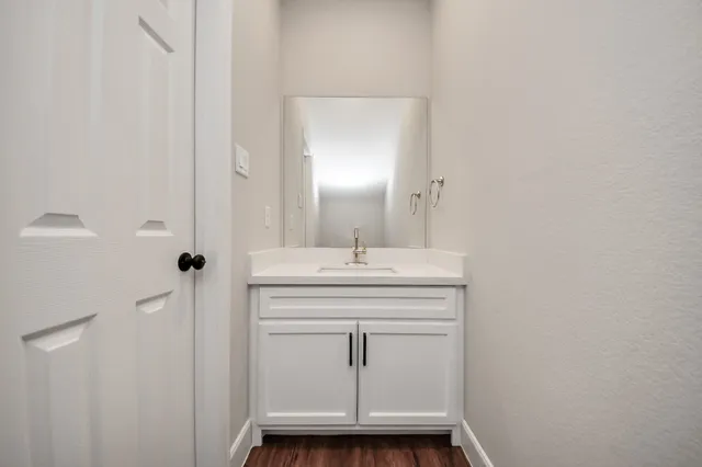 a kitchen with stainless steel appliances granite countertop a refrigerator a sink dishwasher a stove and white countertops with wooden floor