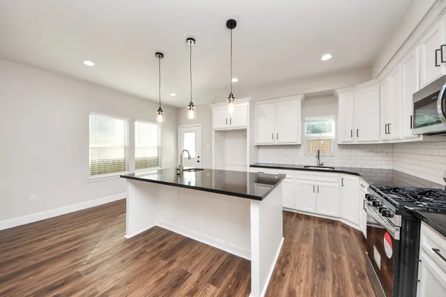 a kitchen with a stove and a wooden floor
