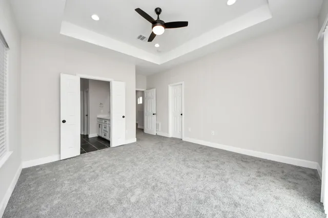 an empty room with fan and windows