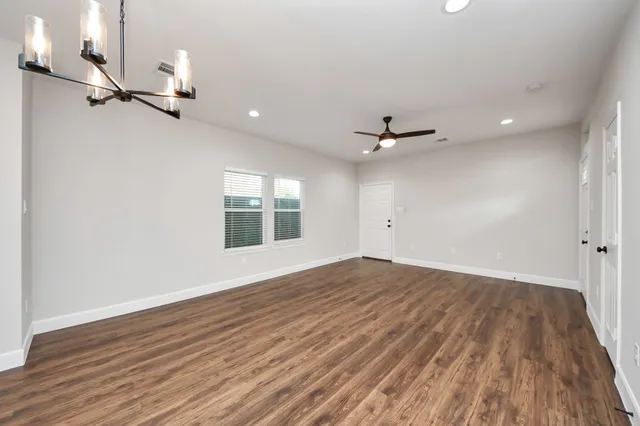 a view of kitchen with kitchen island wooden floor and stainless steel appliances
