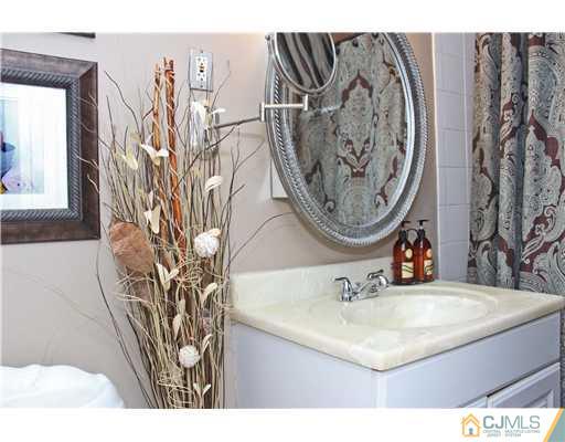 21 Brookville Road Edison, NJ 08817 - Photo 7 of 25 a bathroom with a sink and mirror with bathtub