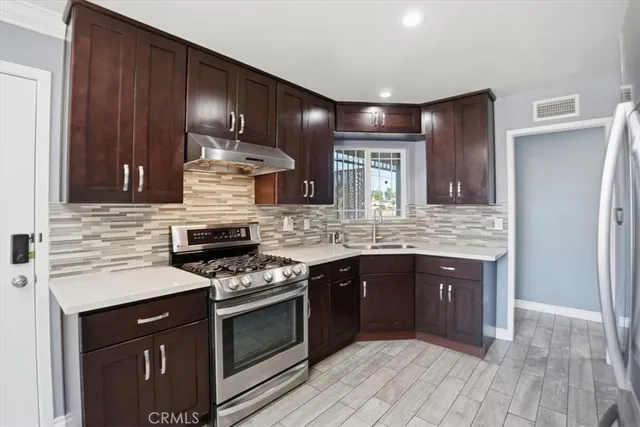 a metallic refrigerator freezer sitting in a kitchen
