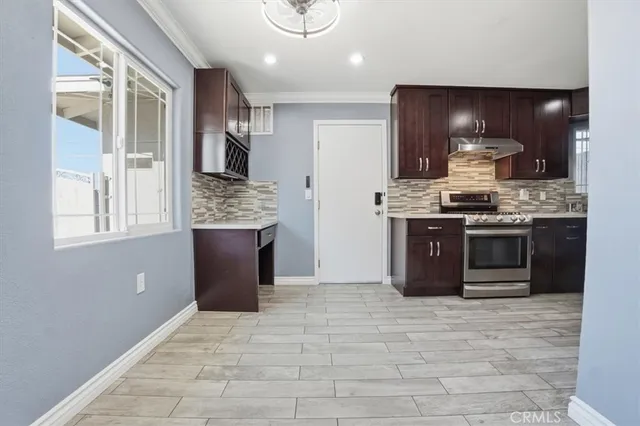 an empty room with kitchen and fireplace