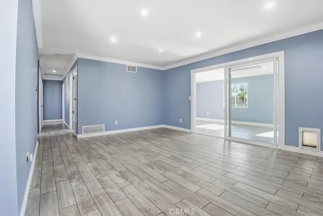 a view of empty room with wooden floor and fireplace