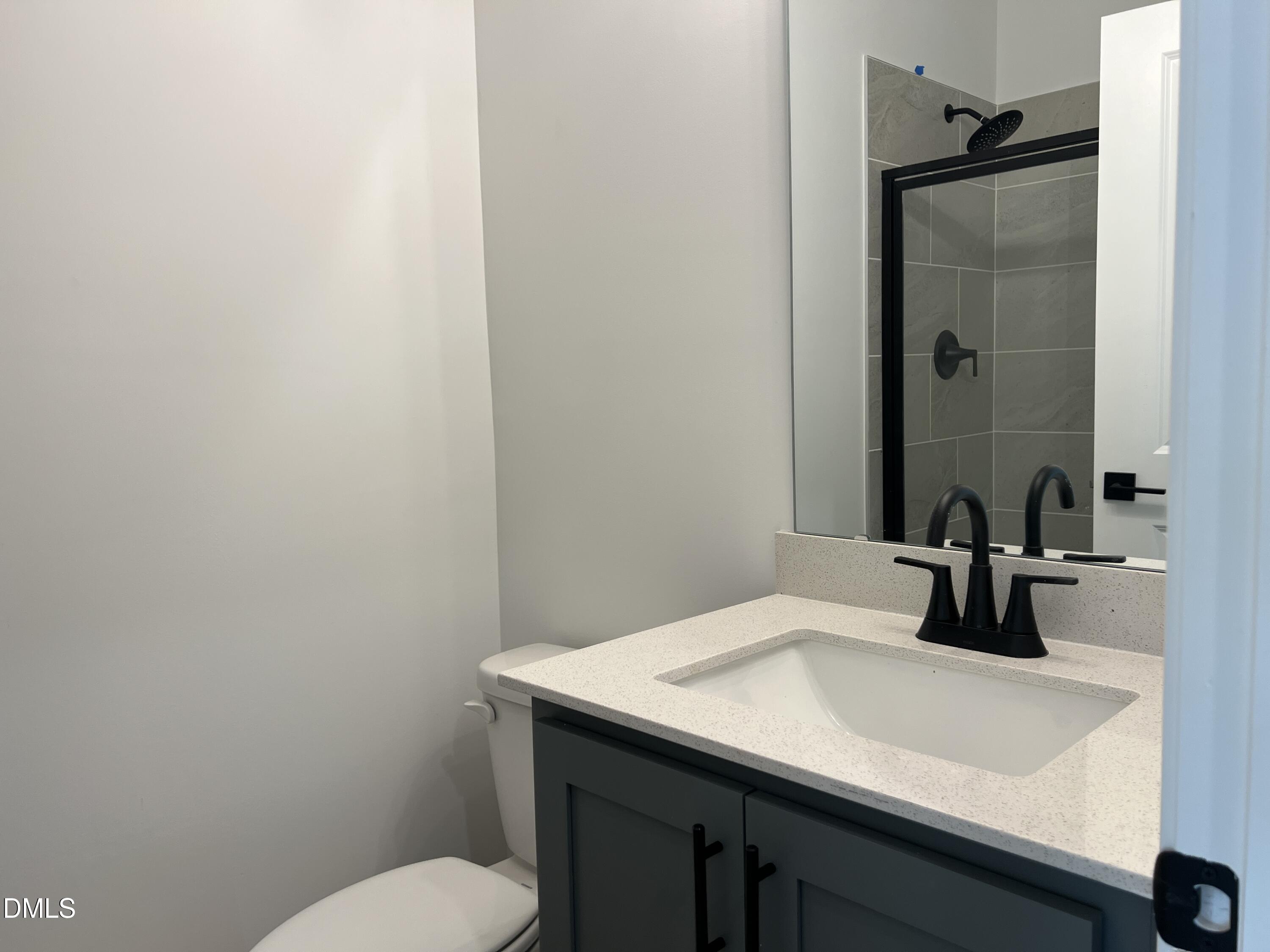 4305 Darius Lane, Unit 27 Willow Spring, NC 27592 - Photo 14 of 18 a bathroom with a sink a toilet and mirror