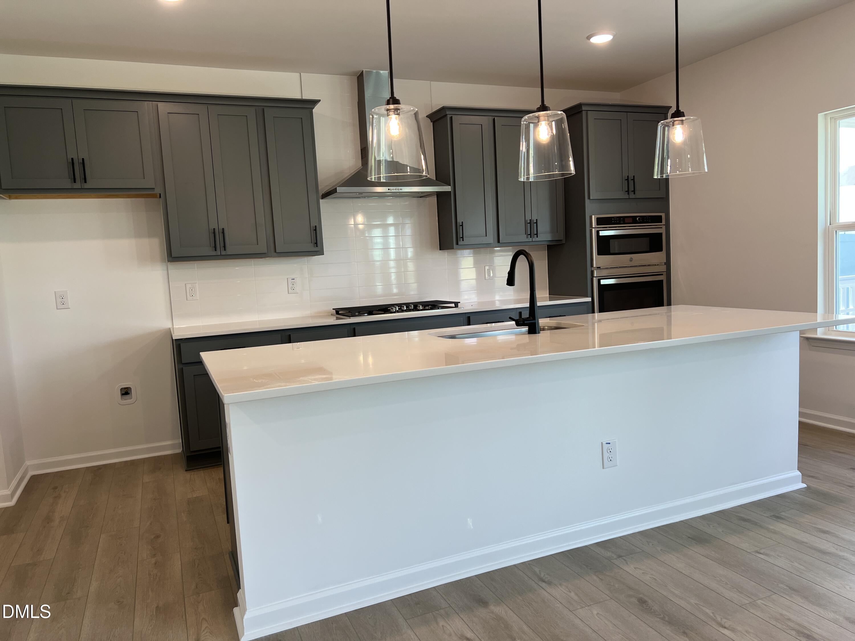4305 Darius Lane, Unit 27 Willow Spring, NC 27592 - Photo 8 of 18 a kitchen with kitchen island a sink stainless steel appliances and cabinets