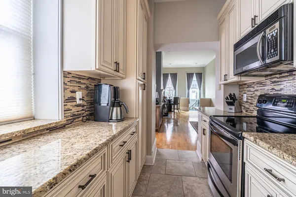 a kitchen with stainless steel appliances granite countertop a sink stove and cabinets