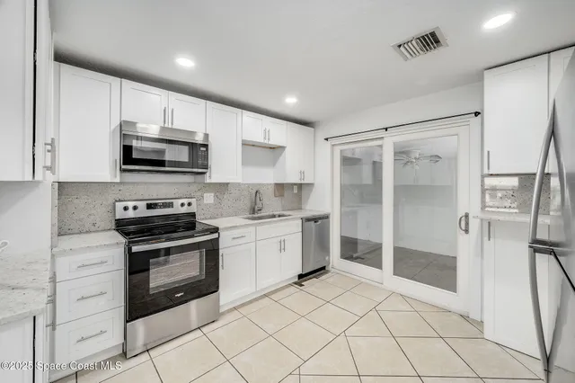 a kitchen with stainless steel appliances granite countertop a refrigerator and a stove top oven