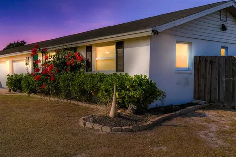 a vase of flowers sitting in front of a house