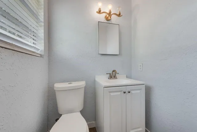 a bathroom with a toilet a sink and mirror