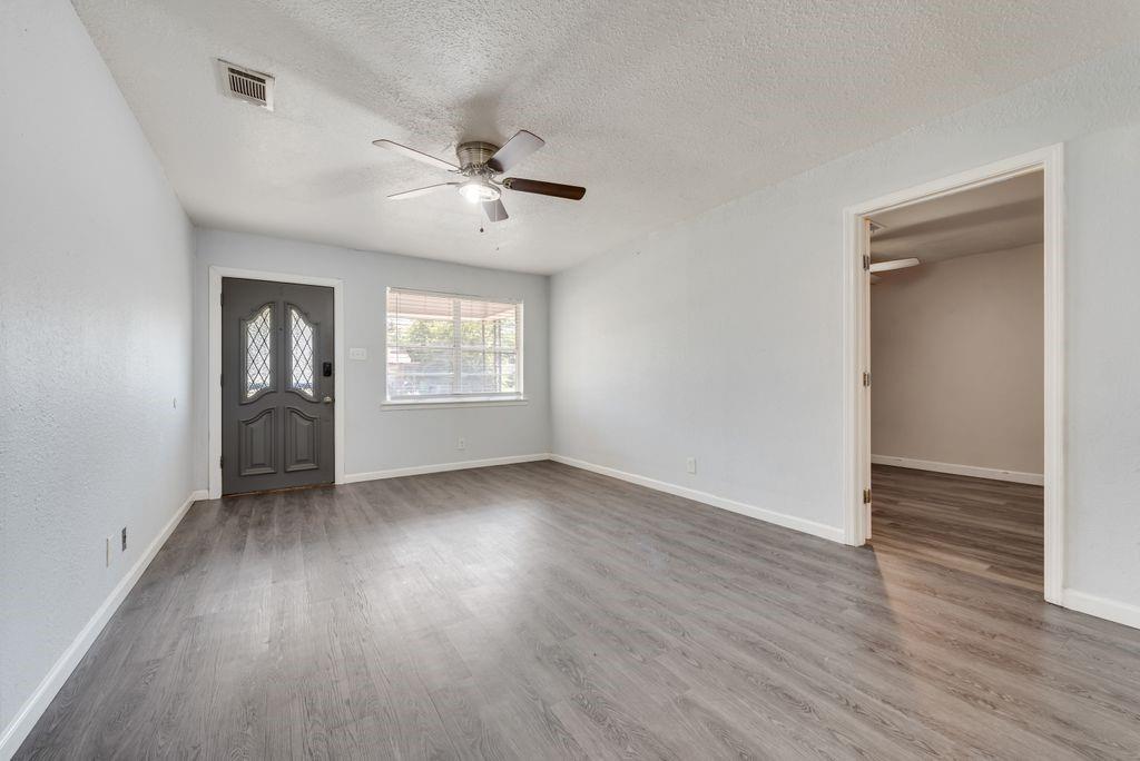 5201 Santa Rosa Drive Haltom City, TX 76117 - Photo 4 of 25 a view of an empty room with a window and wooden floor