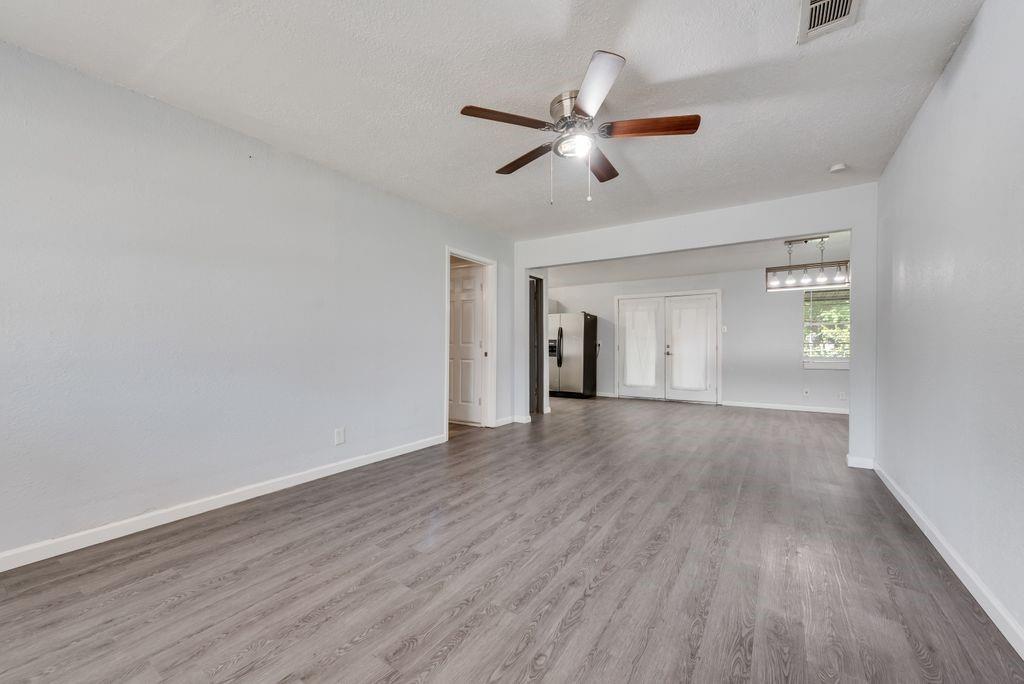 5201 Santa Rosa Drive Haltom City, TX 76117 - Photo 6 of 25 a view of an empty room with wooden floor and a window