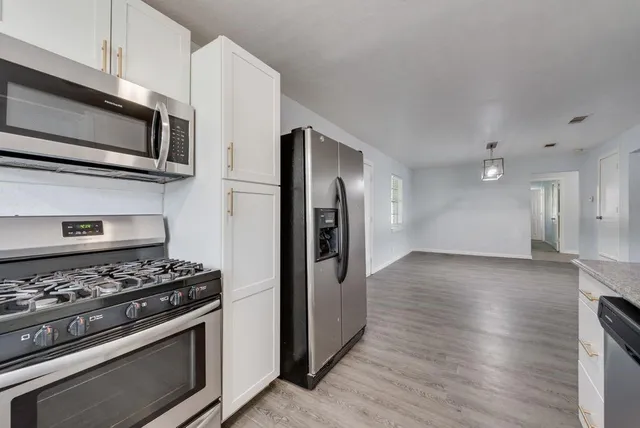 a kitchen with stainless steel appliances granite countertop a stove and a refrigerator