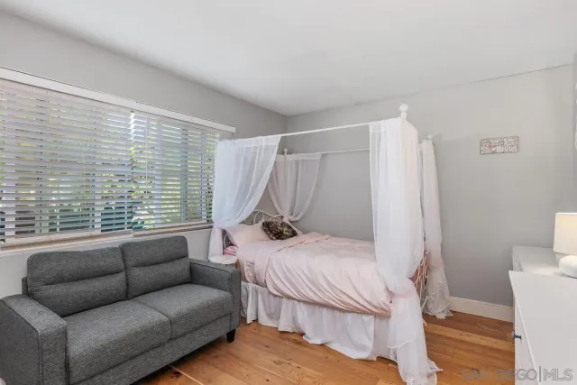 a bedroom with furniture and a large window