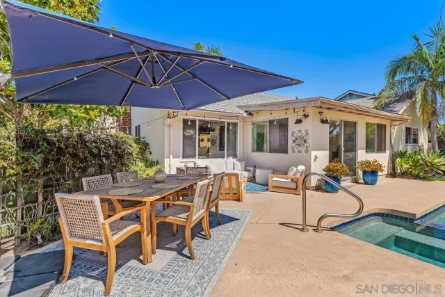a view of a patio with a table and chairs under an umbrella